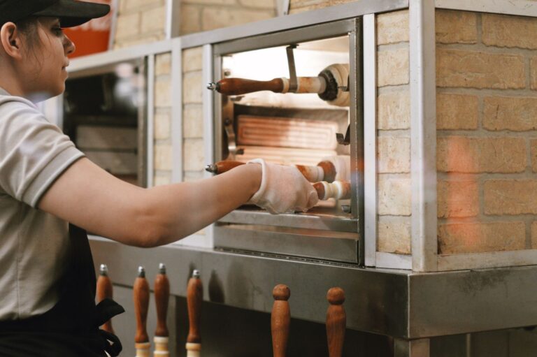 Trabalhadora operando forno de pizzaria