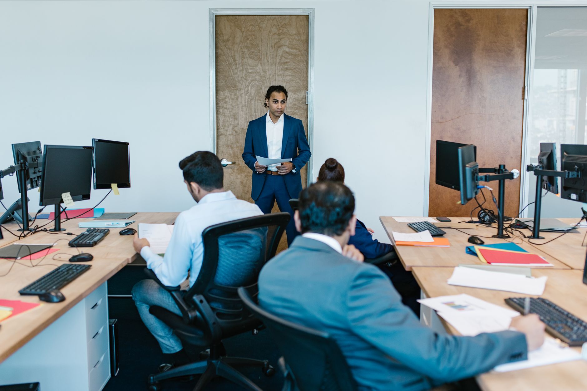 Equipe em reunião no escritório, com a gestora coordenando o trabalho