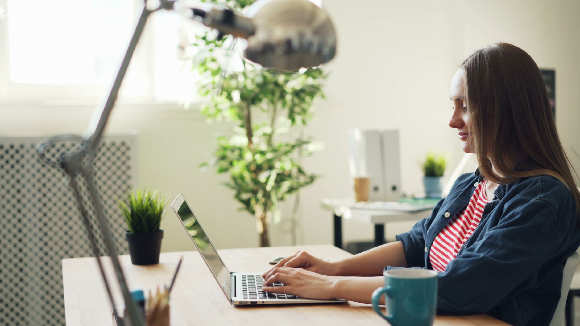 Mulher trabalhando em casa na mesa com notebook