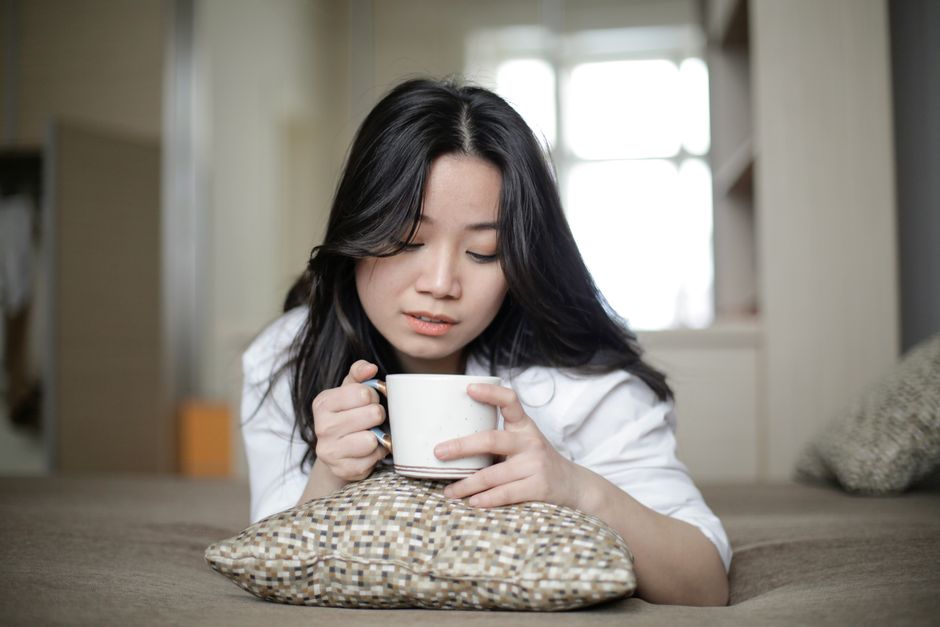 Mulher descansando em casa com uma xícara de café no fim de semana