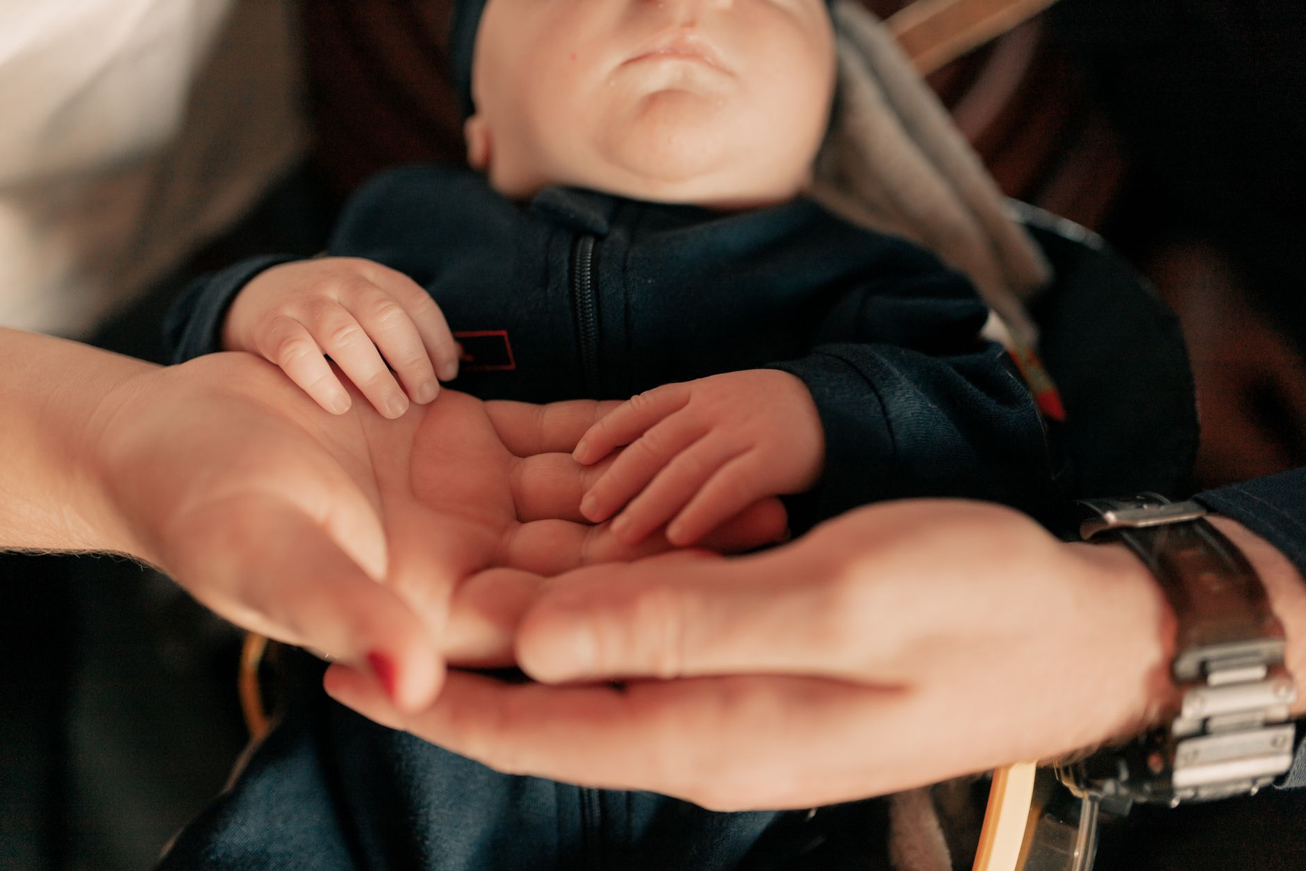 Mãos de pais segurando a mão de um bebê recém-nascido