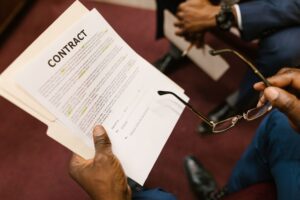 Mãos segurando um contrato em análise