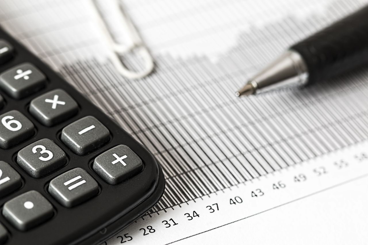 Calculadora e gráfico impresso sobre a mesa representando o cálculo de diferenças salariais