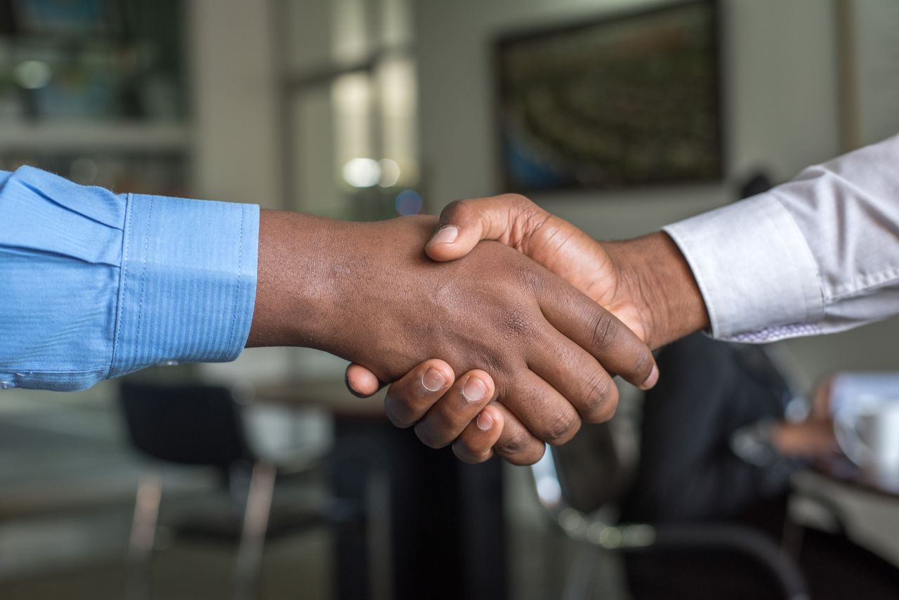Aperto de mãos em ambiente de escritório simbolizando o fim do contrato de trabalho