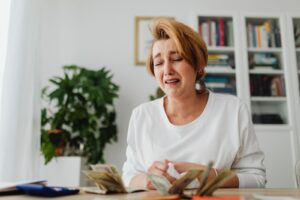 Mulher preocupada contando dinheiro em uma mesa