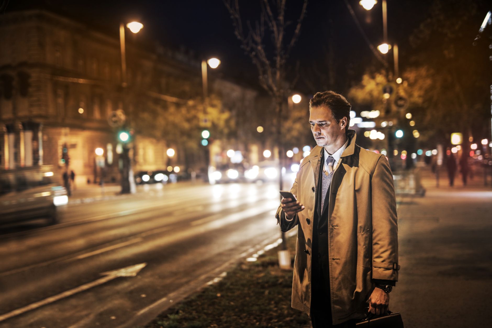 Trabalhador olhando o celular à noite, aguardando chamado da empresa em regime de sobreaviso