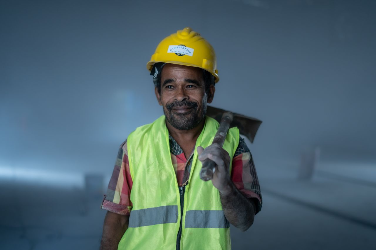 Trabalhador sorrindo com equipamento de segurança