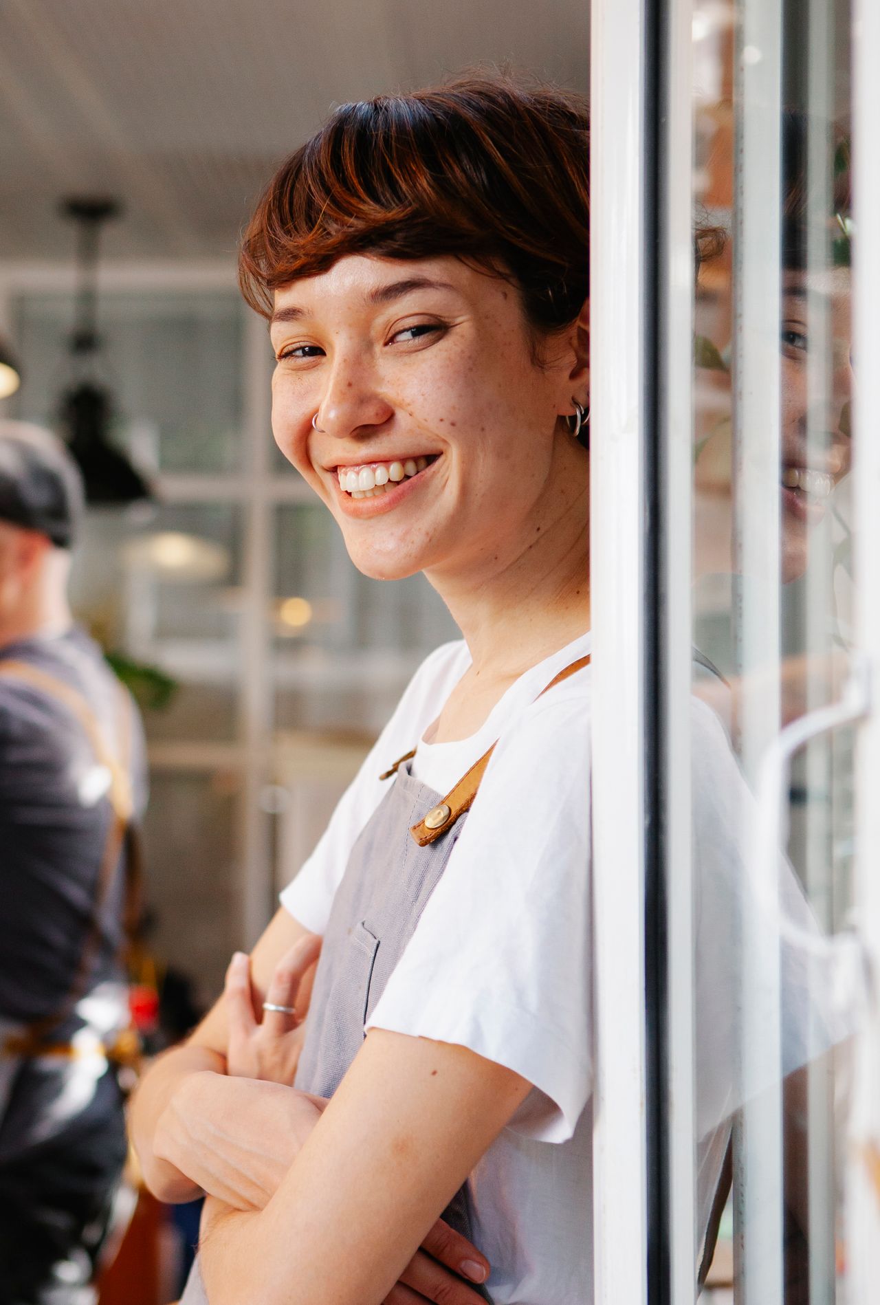 Jovem trabalhadora de avental sorrindo