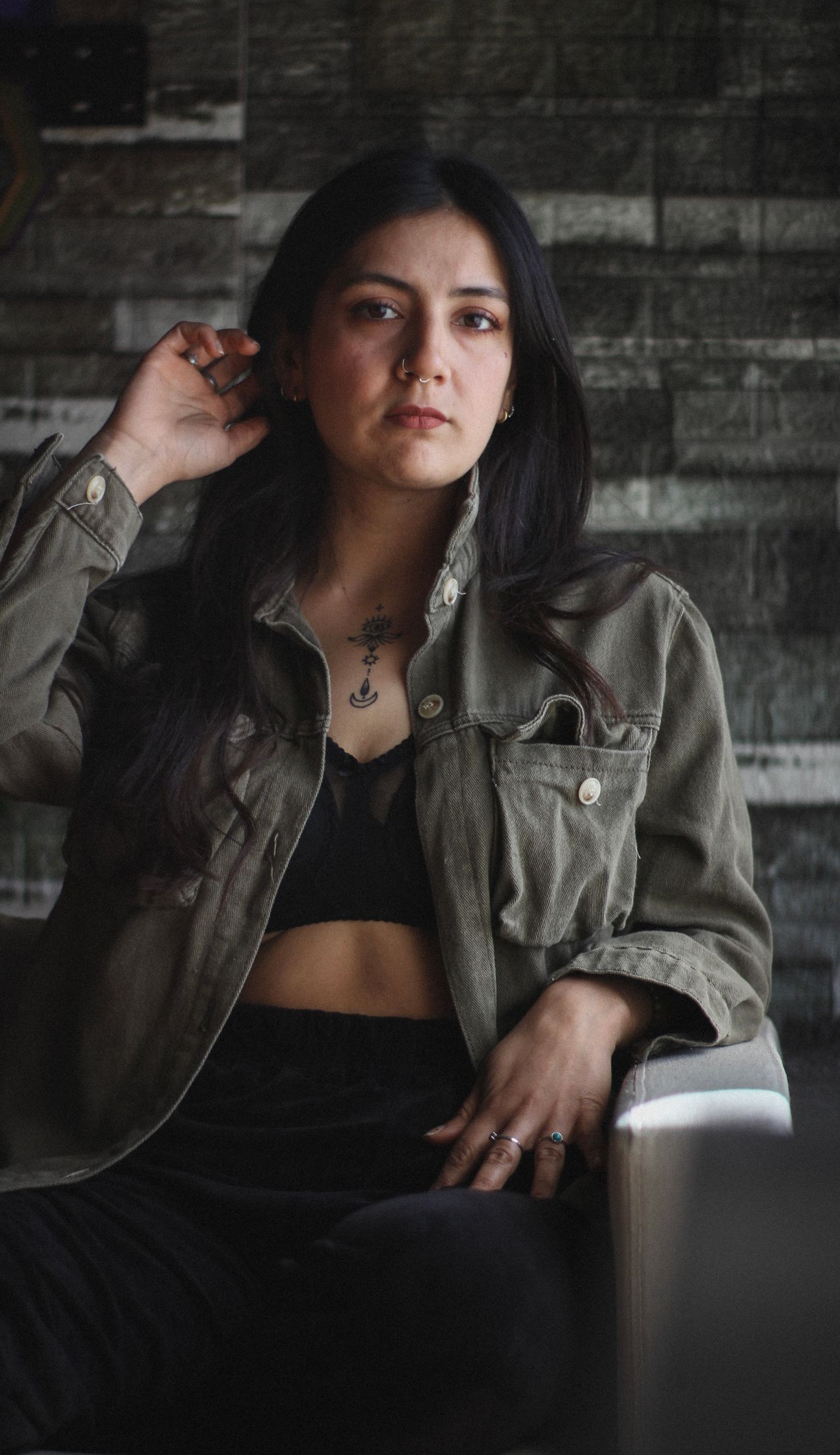 Mulher em retrato com expressão séria, de jaqueta verde